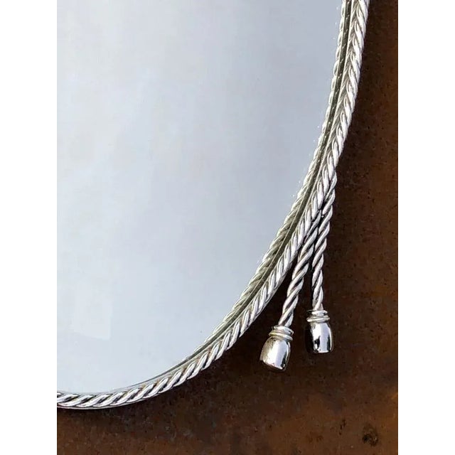 An elegant and luxurious oval wall mirror, art-decal, neo-classical, shabby-chic, in the frame of intertwined rope,...