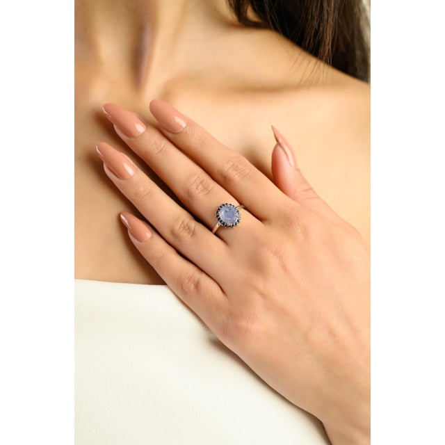 This elegant ring features a 1 oval cut captivating natural cabochon blue star sapphire at the center, weighing...
