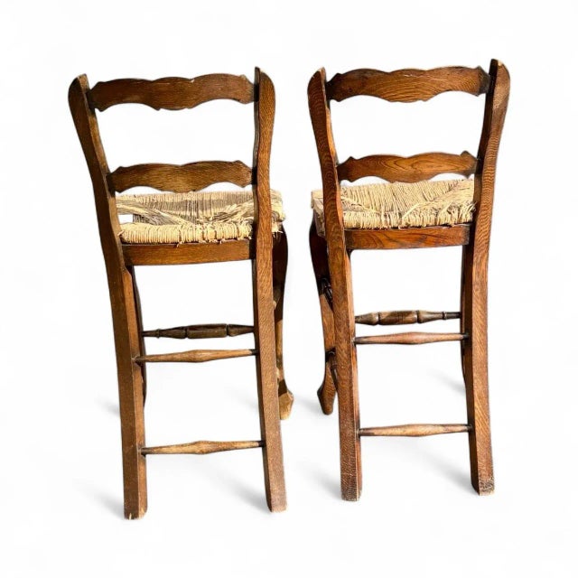 A charming pair of mid-century French Country counter-height barstools, beautifully hand-carved and full of authentic...