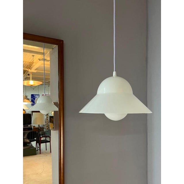 The white plastic pendant lamp by Friis Moltke impresses with its simple and functional design. The lightweight plastic...