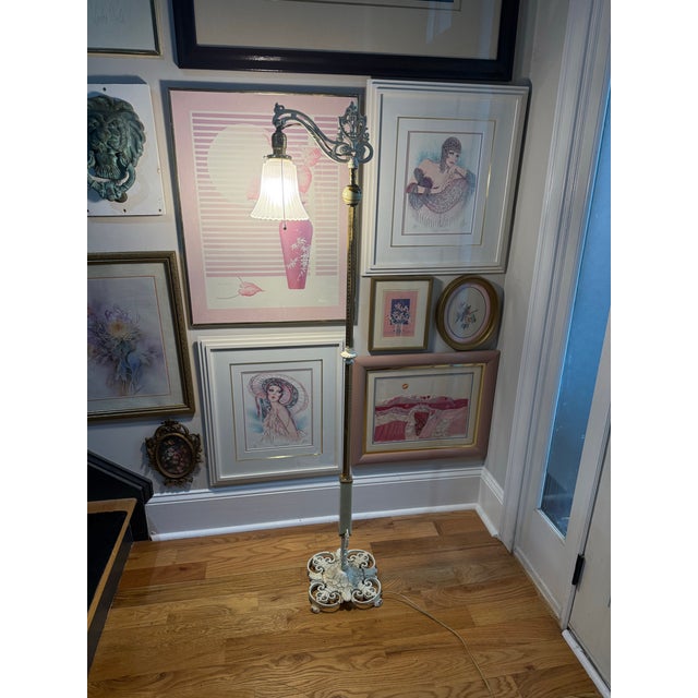 Beautiful vintage floor lamp featuring a heavy cast-iron base with ornate scrollwork and an elegant curved articulating...