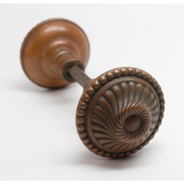 These Colonial style swirl brass doorknobs were made by Corbin in the 1895 catalog. They are part of the E-10700 group....