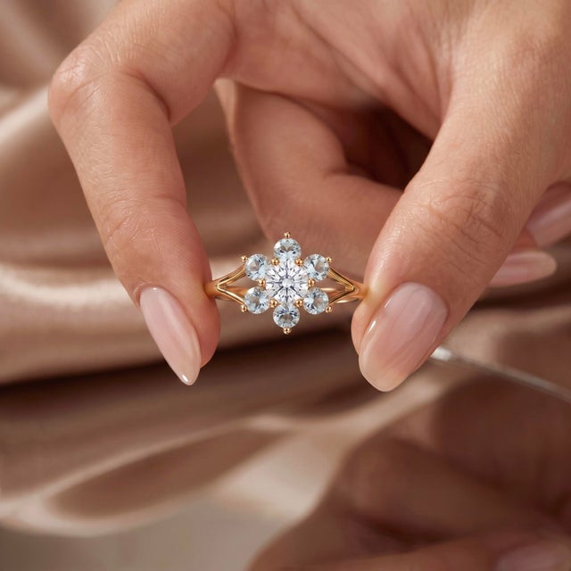 Designed with delicate floral elegance, this vintage-inspired ring features a dazzling clear center gem framed by a halo...