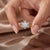Designed with delicate floral elegance, this vintage-inspired ring features a dazzling clear center gem framed by a halo...