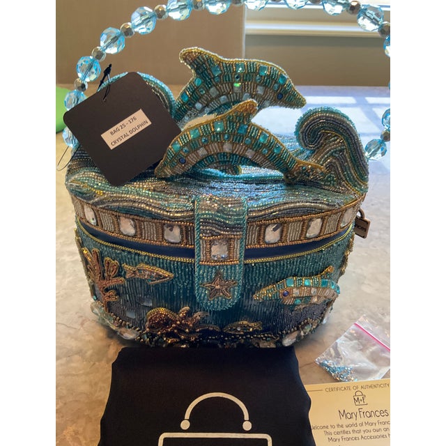 Make waves with this ocean inspired handbag. Featuring hand beaded dolphins leaping over waves with coral, fish, and...
