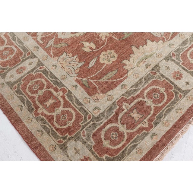 This "New Traditional-Inspired" rug is hand-woven in flat-weave wool with a softly variegated beige ground that shows...