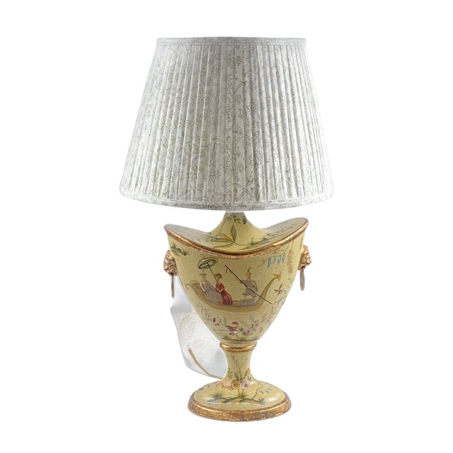 A Chinoiserie decorated and gold gilt pair of table lamps with gilt lion handles and coin medallion finials. Lamps measure...