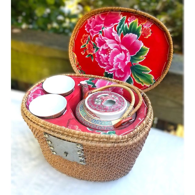 A vintage Chinese teapot and two cups are tucked into a colorful lined tea cozy basket. The finely woven basket is lined...