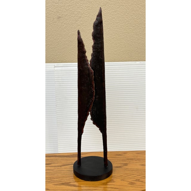 Design Plus Gallery presents an Unmarked Cast Metal Sculpture. This is a tall, abstract metal sculpture that has two...