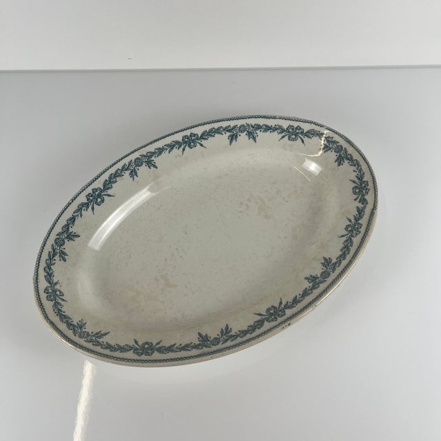 Oval earthenware platter, "Laurels" pattern, by Moulins des Loups - Hamage, 1900 Dimensions: 31.5 x 22 cm Height: 4 cm...