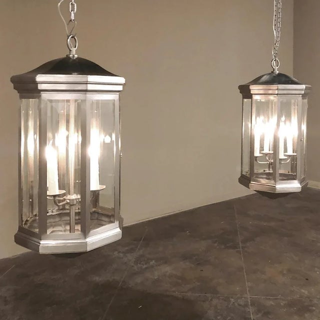 Pair Mid-Century Brushed Steel Lantern Chandeliers were crafted in an octagonal design with beveled glass on each facet,...