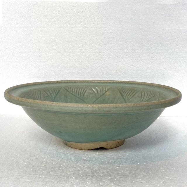 DETAILS An antique pottery bowl with flared rim. The interior with incised and combed lotus floral decoration. Lotus...