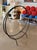 This mid-century modern fireplace log holder, produced circa 1950–1960, is constructed from solid wrought iron with a...