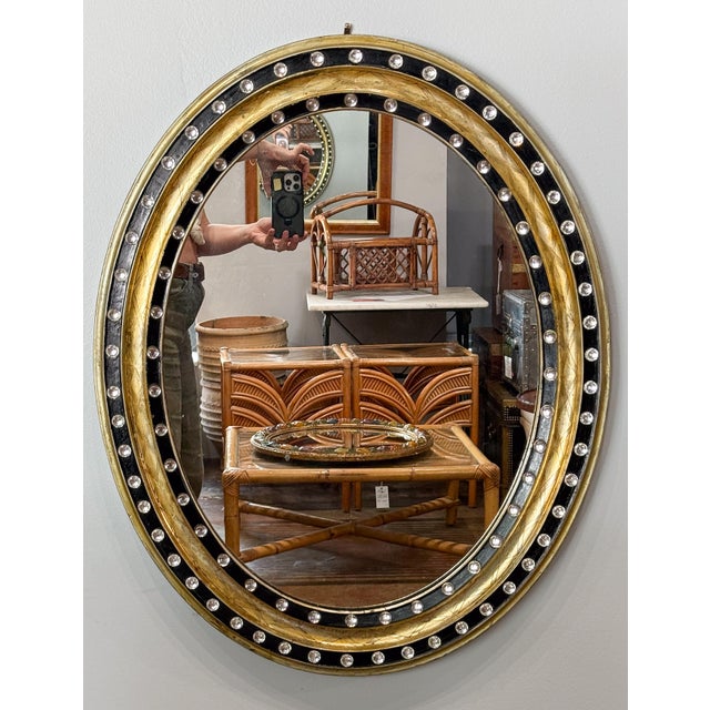 A fine Irish oval wall mirror from the early 19th century, featuring a distinctive frame of alternating raised ebonized...
