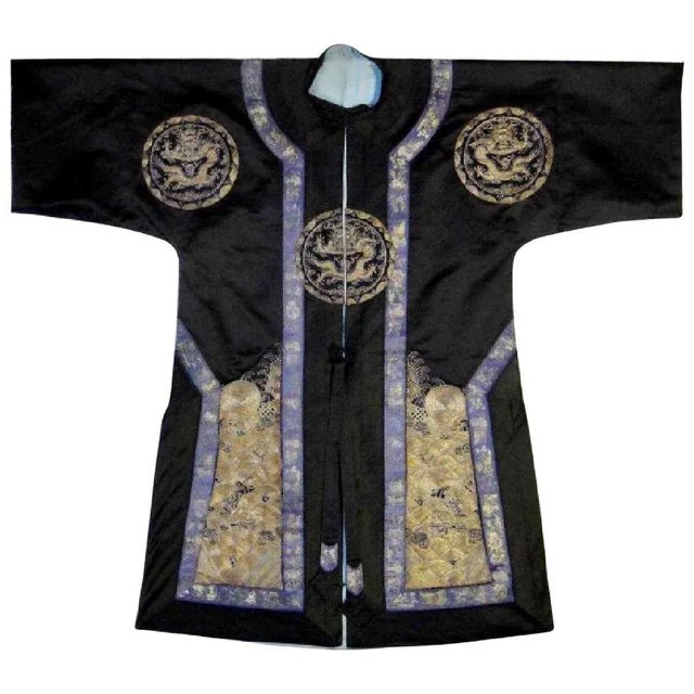A black silk robe with three medallions of five-clawed dragons and thousands of ocean waves borders, all done in a...