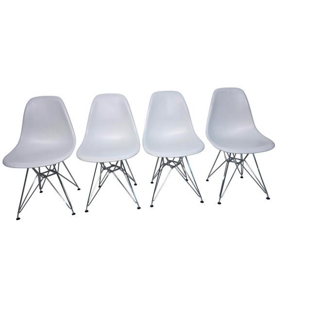 Eames for Knoll molded white plastic chairs with iconic stainless steel Eiffel Tour bases.Marked Eames for Knoll A more...