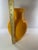 This striking 11.5-inch tall hand-blown cased glass vase features a vibrant, high-gloss yellow exterior with a contrasting...