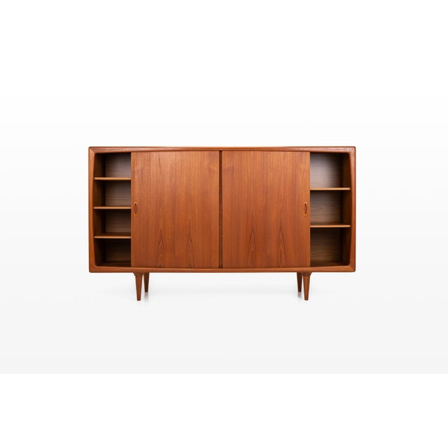 An elegant danish vintage highboard in teak by h.p. Hansen, featuring a softly rounded frame, recessed oval handles and...