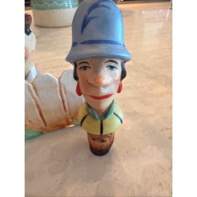 Add a touch of 1930s whimsy to your bar collection with this rare, hand-painted porcelain bottle stopper set. Featuring a...