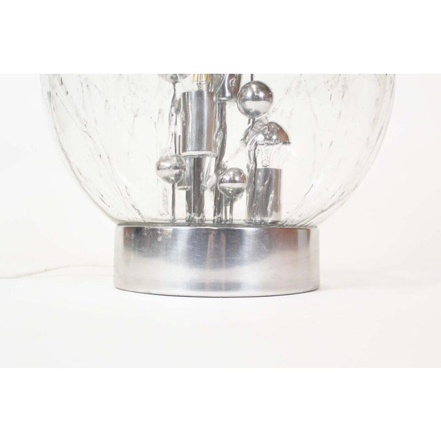 Stunning and iconic ice glass table lamp by Doria Leuchten, made in Germany during the 1960’s. Chrome base with sputnik...