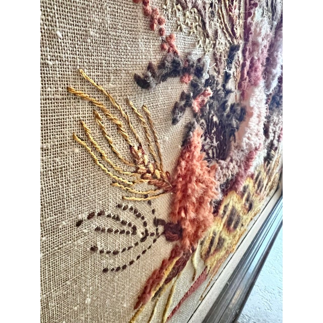 Beautiful embroidered floral crewel in a brown wood frame. It is larger than most crewel pieces we’ve had. Lots of texture...