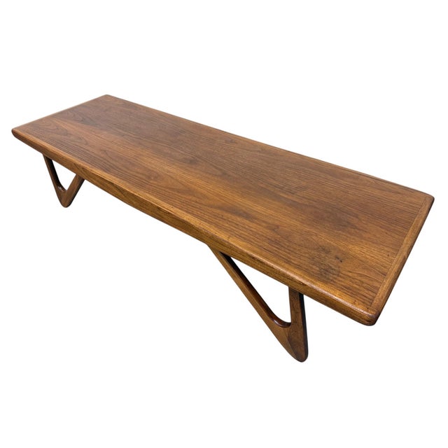Make a statement with this striking mid-century modern walnut coffee table, circa 1960s. Featuring a beautifully sculpted...