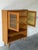 This versatile display cabinet features upper glass doors with leaded details, open lower shelving, and slender tapered...