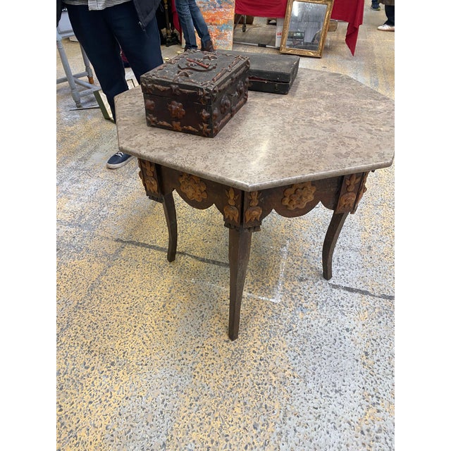 French octagon tramp art table with applied decorative pinecone scales on the scalloped apron and tapered legs with a gray...