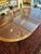 This versatile banded drop leaf mahogany dining table was produced by Baker Furniture Company. It was purchased at Gump's...