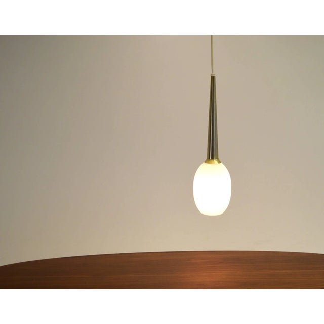 Lightolier, 1965, Brass, Blown Glass, 8" wide, body is 20.5" long, variable drop. Pendant lamp specifically designed for a...