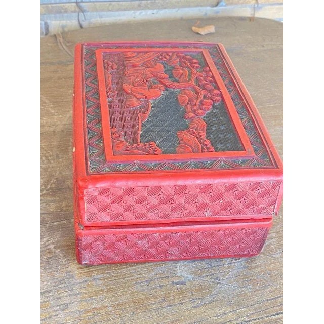 Red lacquer box with the lid representing a scholar and children playing in a mountainous garden, the outer sides covered...