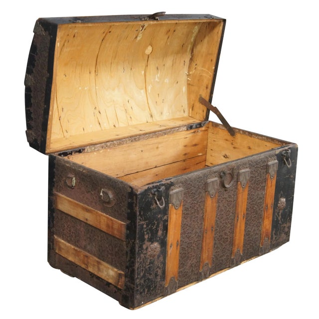 A charming antique 19th century steamer trunk. Made from oak with metal paneling and banding. The center of the trunk has...