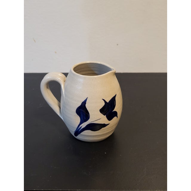 This is a Colonial Williamsburg Pottery creamer from the 70s. It is painted with cobalt blue flowers and leaves and is...