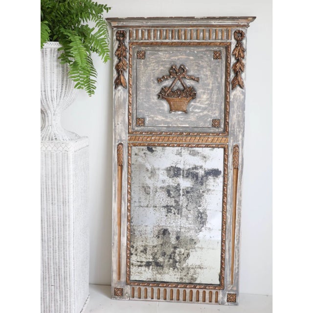 The Antique French Mirror showcases exquisite craftsmanship with its bronze-like finish and delicately carved wood frame....