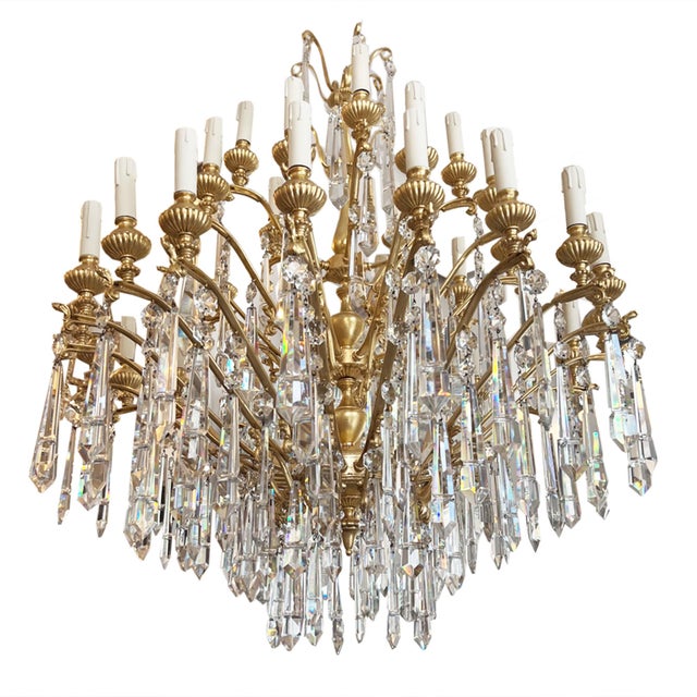 This is an exceptional gilded brass and crystal chandelier, a grand statement piece , richly adorned with hand-cut glass...
