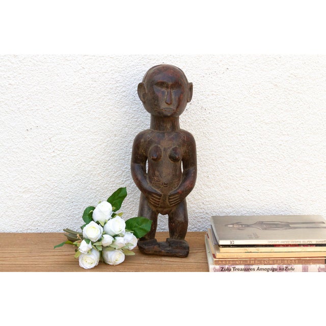 This antique Baule maternity figure, carved from wood with a smooth, rich patina, embodies the reverence for motherhood...