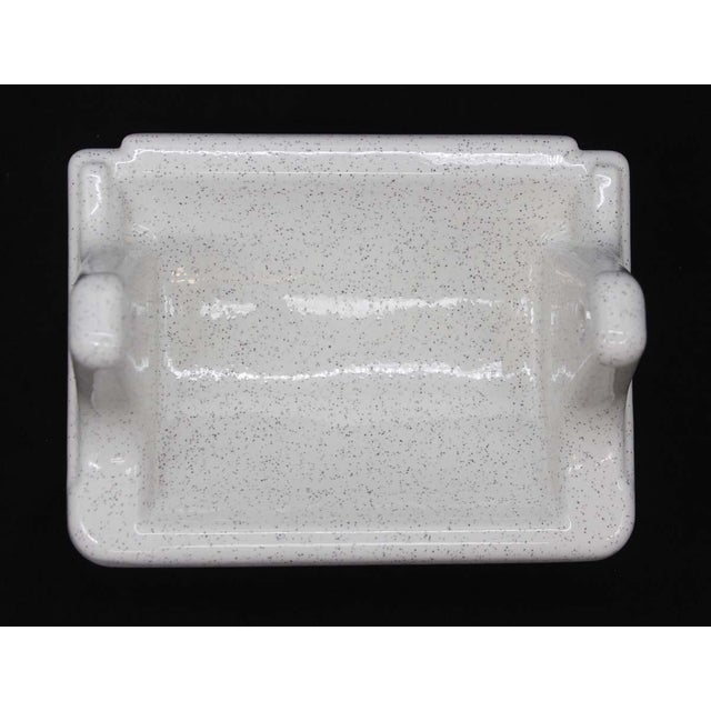 Reclaimed vintage flush mount wall mount toilet paper holder made of ceramic with a porcelain finish. It is white in color...