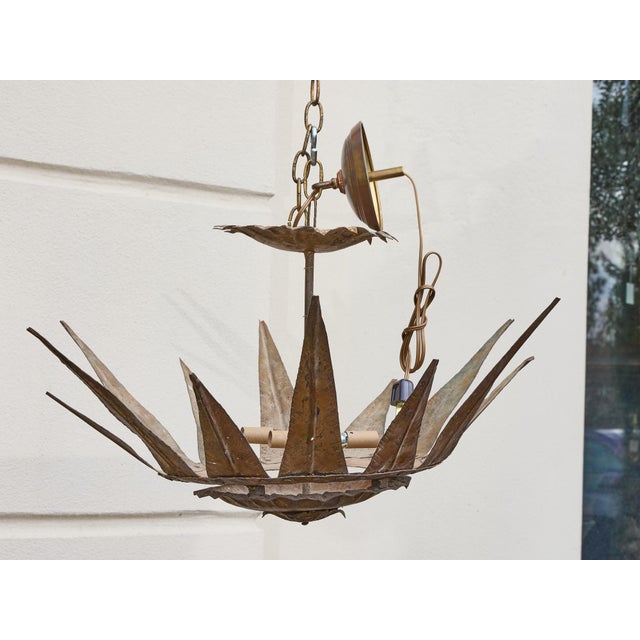 A dramatic midcentury Spanish gilt metal chandelier with a bold sunburst crown form and four interior lights. Hand-forged...