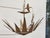 A dramatic midcentury Spanish gilt metal chandelier with a bold sunburst crown form and four interior lights. Hand-forged...