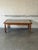 This striking coffee table features an inset ceramic tile top with intricate floral patterns and sturdy turned legs....