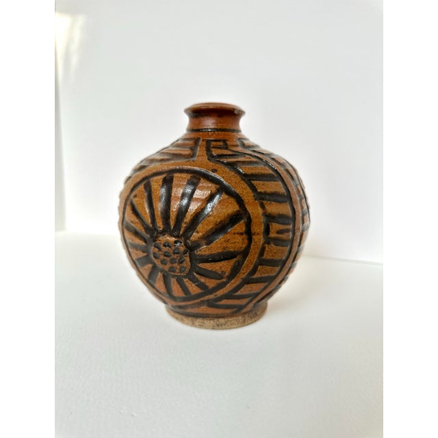 Discover the charm of hand-crafted design with this graphic mid-century pottery vase. Its hand-applied tribal floral motif...