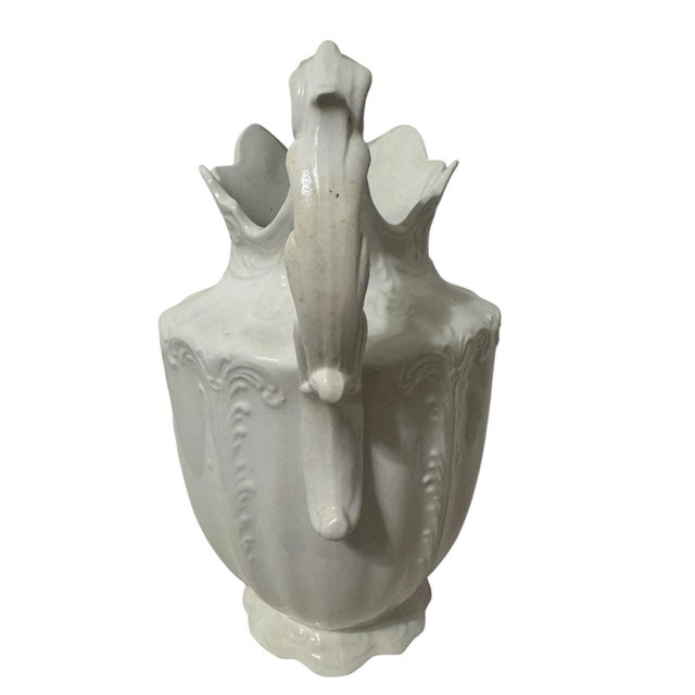 A commanding antique white ironstone ewer by C.P. Marquette Co., produced as the centerpiece of a Victorian washbowl...