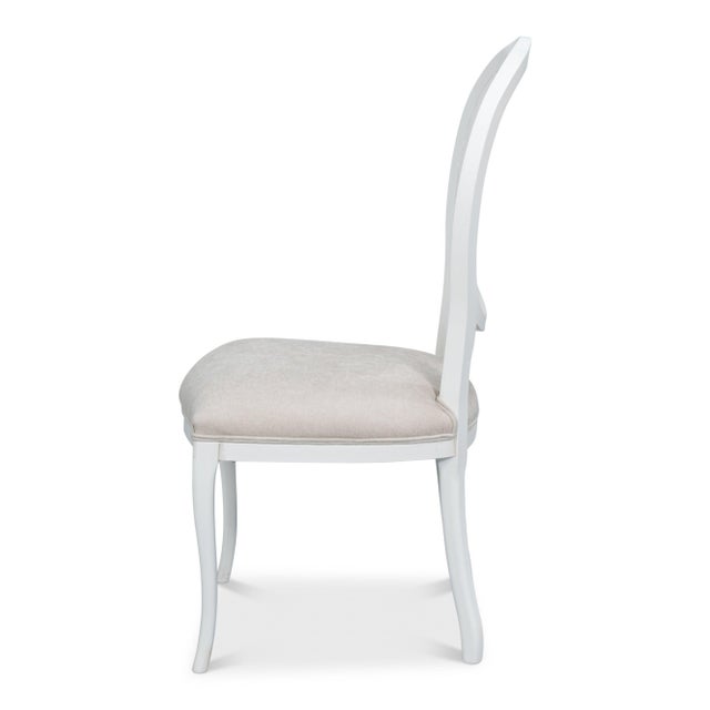 White paint brings out the molded oval surround, shaped knees, and carved beechwood ribbon framing the woven back. The...