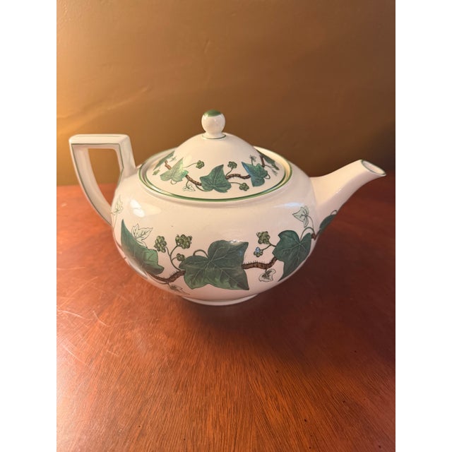 The product is a rare vintage Wedgwood Napoleon Ivy teapot in green Queen's Ware bone china, made in England in 1815. This...