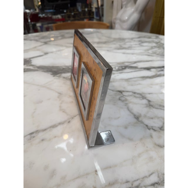 Elegant vintage double photo frame featuring a rich burl wood veneer panel accented by a polished chrome border. The frame...