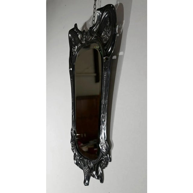 This mirror with ice around beveled has an openwork frame in silver metal. This one is worked with country ornaments: ears...