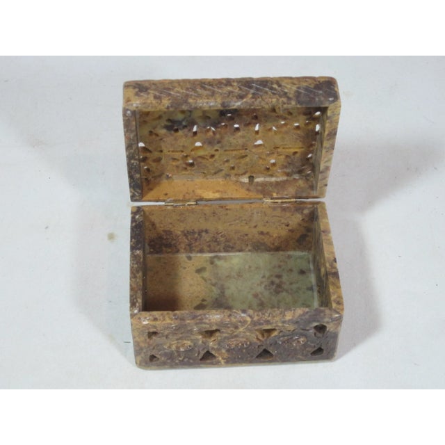 Hand carved pierced soap stone box decorated with elephants, scrolls and floral motifs with hinged top.