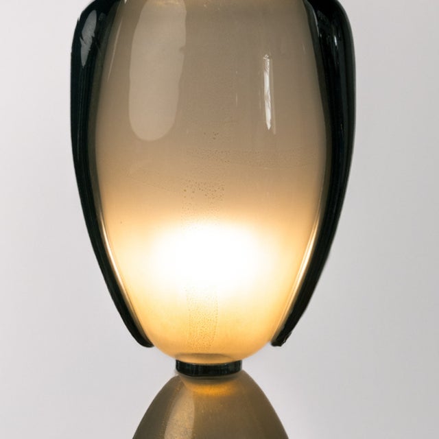 Pair of iridescent Murano glass table lamps. This piece is shaped like a large goblet or hourglass in iridescent white...