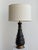 Mid century modern ebonized wood and antique finish brass plated table lamp. The lamp base has a 6.5 inch diameter....