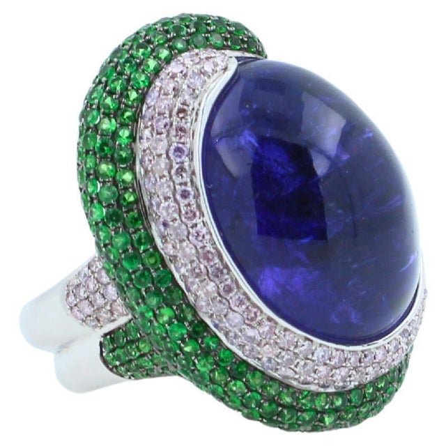Tanzanite Oval Cabochon 50.00 Carats Dark Sea Blue Color & Hues Tsavorites 1.25 ctw Diamonds 1.25 ctw 18K White Gold 26.80...